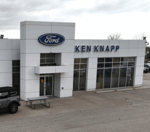 Ford dealership exterior with "Ken Knapp" signage, large windows, and parked vehicle.